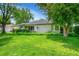 Beautifully landscaped front yard with lush green grass and mature trees surrounding the charming home at 1935 Oneida St, Denver, CO 80220