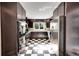 Modern kitchen with stainless steel appliances, dark cabinetry, and black and white tiled floor at 1935 Oneida St, Denver, CO 80220