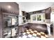 Updated kitchen features dark cabinets, granite counters, wine rack and black-and-white checkered floor at 1935 Oneida St, Denver, CO 80220