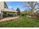 A landscaped backyard featuring a covered patio and large grassy area at 6769 E Costilla Cir, Centennial, CO 80112