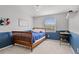 A cozy bedroom featuring a bed with a blue comforter, and a window providing natural light at 6769 E Costilla Cir, Centennial, CO 80112