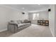 Cozy basement living room with a large sectional couch, window, and minimalist decor at 6769 E Costilla Cir, Centennial, CO 80112