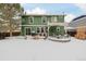 Green house exterior and snowy backyard with a pergola and patio furniture at 6344 E 137Th Ave, Thornton, CO 80602