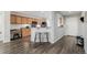 Kitchen with wood cabinets, island, and entryway with dark laminate flooring at 6344 E 137Th Ave, Thornton, CO 80602