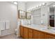 Bathroom with double sinks, wood cabinets, tiled floors, and a large mirror with vanity lighting at 1281 S Allison St, Lakewood, CO 80232