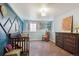 Bright Bedroom with a crib, rocking chair, dresser and mountain themed wall art at 1281 S Allison St, Lakewood, CO 80232