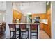 Well-lit kitchen with tile floors, light wood cabinets, stainless steel appliances, and bar-style seating at 1281 S Allison St, Lakewood, CO 80232