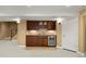 Finished basement wet bar with dark cabinets, wine storage, and stainless steel mini fridge at 1544 S Elizabeth St, Denver, CO 80210
