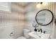 Stylish powder room features patterned wallpaper, pedestal sink, and modern fixtures at 1544 S Elizabeth St, Denver, CO 80210