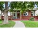 Inviting front porch with brick and wood accents, leading to a well-manicured lawn at 1544 S Elizabeth St, Denver, CO 80210