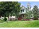 Charming two-story home featuring a well-maintained lawn, mature trees, and a welcoming front porch at 1544 S Elizabeth St, Denver, CO 80210