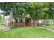 Charming home with a covered porch and a lush green lawn, shaded by a mature tree at 1544 S Elizabeth St, Denver, CO 80210