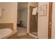 Bright bathroom with a glass shower, soaking tub and a view into the bedroom space at 4315 Bella Vista Dr, Longmont, CO 80503