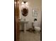 Cozy half bathroom with modern pedestal sink, stylish fixtures, and wood-look flooring at 4315 Bella Vista Dr, Longmont, CO 80503