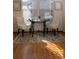 Cozy dining area featuring a glass table, contemporary chairs, and hardwood floors with decorative rug at 4315 Bella Vista Dr, Longmont, CO 80503