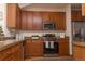 Stylish kitchen featuring wood cabinets, granite countertops, stainless steel appliances, and a warm color palette at 4315 Bella Vista Dr, Longmont, CO 80503