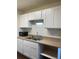 Kitchen featuring white cabinets, tan countertops, and stainless steel sink at 10792 E Exposition Ave # 352, Aurora, CO 80012