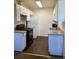 Kitchen with black appliances, white cabinets, and vinyl flooring at 10792 E Exposition Ave # 352, Aurora, CO 80012