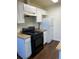 The kitchen features sleek, black appliances, white cabinets, and a beige countertop finish at 10792 E Exposition Ave # 352, Aurora, CO 80012