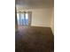 Empty living room with plush carpet, curtains, and sliding glass doors at 10792 E Exposition Ave # 352, Aurora, CO 80012