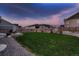 Spacious backyard with a large lawn, fenced perimeter, and a concrete patio with seating area at 11560 Kalispell St, Commerce City, CO 80022