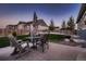 Backyard featuring a well-manicured lawn, a stained wood fence, and a concrete patio seating area at 11560 Kalispell St, Commerce City, CO 80022