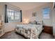 Comfortable bedroom featuring a large window, soft carpet, and a cozy bed with floral quilt at 11560 Kalispell St, Commerce City, CO 80022