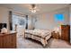 Cozy bedroom features neutral walls, plush carpet, and a comfortable bed with nature-themed quilt at 11560 Kalispell St, Commerce City, CO 80022