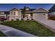 Charming two-story home with stone accents, a well-manicured lawn, and a driveway leading to a two-car garage at 11560 Kalispell St, Commerce City, CO 80022