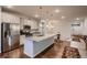 Modern kitchen with a large island, stainless steel appliances, and stylish pendant lighting at 11560 Kalispell St, Commerce City, CO 80022