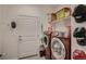 Well-lit laundry room with storage shelves above the stacked, modern washer and dryer units at 11560 Kalispell St, Commerce City, CO 80022