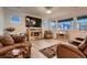 Comfortable living room with large windows, a fireplace, and a cozy seating area at 11560 Kalispell St, Commerce City, CO 80022