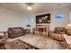 Cozy living room features a rustic electric fireplace, comfortable leather seating, and wood-look flooring at 11560 Kalispell St, Commerce City, CO 80022