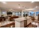 Open-concept living space with a kitchen island, fireplace, and lots of natural light from the windows at 11560 Kalispell St, Commerce City, CO 80022
