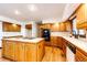This kitchen features wood cabinets, laminate countertops, an island cooktop and hardwood floors at 6936 S Chapparal W Cir, Centennial, CO 80016