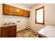 Laundry room with wooden cabinets, a sink and tile flooring at 6936 S Chapparal W Cir, Centennial, CO 80016
