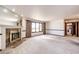 Bright living room with marble fireplace, large window with view, and neutral carpeting at 6936 S Chapparal W Cir, Centennial, CO 80016
