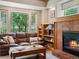 Comfortable living room with a cozy fireplace, built-in shelves, and large windows at 1250 S Boyero Ct, Superior, CO 80027