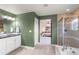 Well-lit bathroom featuring double sink, tile flooring and shower, and an open doorway to an airy bedroom at 3116 Black Canyon Way, Castle Rock, CO 80109