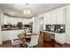Bright kitchen and dining area featuring hardwood floors, white cabinetry, and stylish decor at 3116 Black Canyon Way, Castle Rock, CO 80109