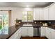 Well-lit kitchen featuring granite countertops, stainless steel appliances and white cabinetry at 3116 Black Canyon Way, Castle Rock, CO 80109