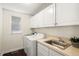 Efficient laundry room featuring side-by-side washer and dryer with overhead cabinets and stainless steel sink at 3116 Black Canyon Way, Castle Rock, CO 80109