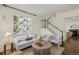 Cozy living room with hardwood floors, neutral decor, white staircase and lots of natural light at 3116 Black Canyon Way, Castle Rock, CO 80109