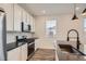 Kitchen features stainless steel appliances, white cabinets, dark counters, and wood-look floors at 2507 W 69Th Pl, Denver, CO 80221