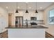 Modern kitchen featuring stainless steel appliances, dark counters, and pendant lighting at 2507 W 69Th Pl, Denver, CO 80221