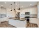 Bright kitchen with stainless steel appliances, white cabinets, and pendant lighting over island at 2507 W 69Th Pl, Denver, CO 80221