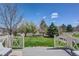 Landscaped backyard with green grass and a white picket fence viewed from a deck at 3802 Chaffee Ct, Castle Rock, CO 80109
