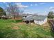 Wide backyard showcasing green grass, a covered patio, and a detached storage shed against a clear sky at 16533 E Baker Pl, Aurora, CO 80013