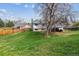 Scenic backyard view showcasing a spacious lawn, mature trees, and a covered patio for outdoor enjoyment at 16533 E Baker Pl, Aurora, CO 80013