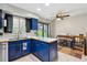 Bright kitchen with blue cabinetry, stainless steel appliances, and sink under a window with backyard view at 16533 E Baker Pl, Aurora, CO 80013